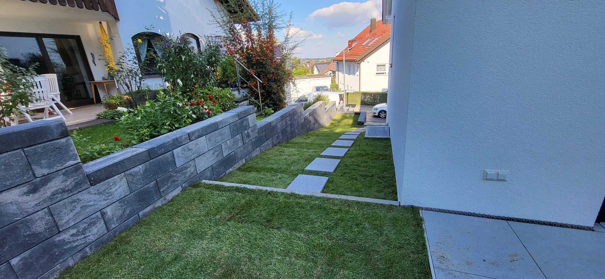 Terrasse mit großformatigen Platten und Hangabfangung